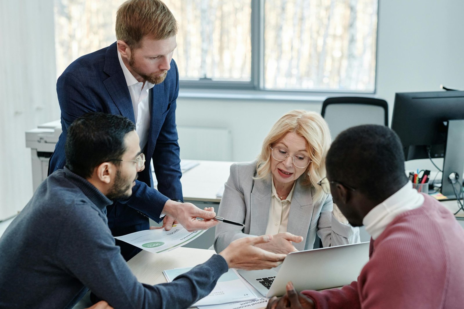 Consultor explicando estrategia a clientes frente a una pantalla con gráficos